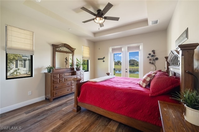 bedroom featuring access to exterior, ceiling fan, french doors, a raised ceiling, and dark hardwood / wood-style flooring