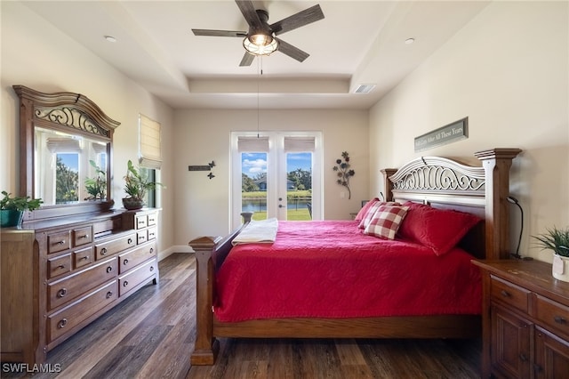 bedroom with access to exterior, french doors, a raised ceiling, ceiling fan, and dark wood-type flooring