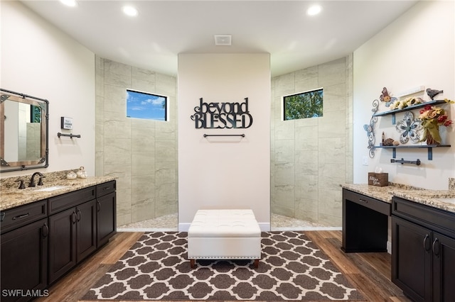 bathroom featuring hardwood / wood-style floors, vanity, and tiled shower