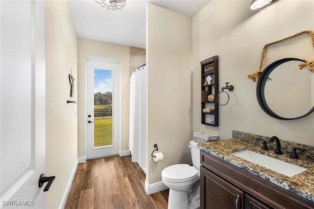 bathroom with wood-type flooring, vanity, and toilet