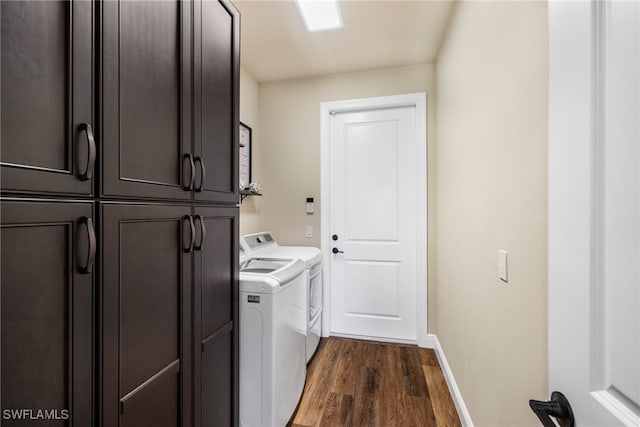 laundry area featuring cabinets, dark hardwood / wood-style flooring, and washing machine and dryer