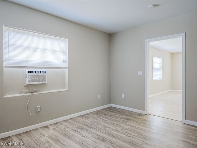 empty room featuring cooling unit and light wood-type flooring