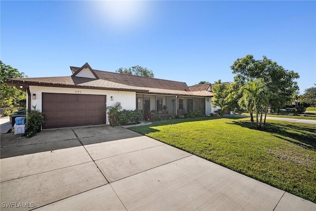 single story home featuring a front lawn and a garage