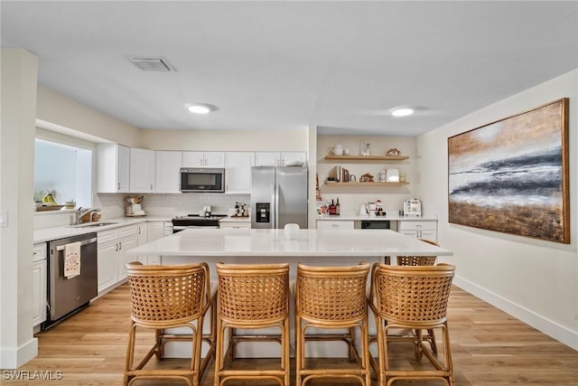 kitchen with white cabinets, stainless steel appliances, and a center island