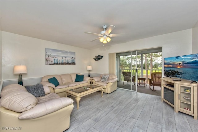 living room with light wood-type flooring and ceiling fan