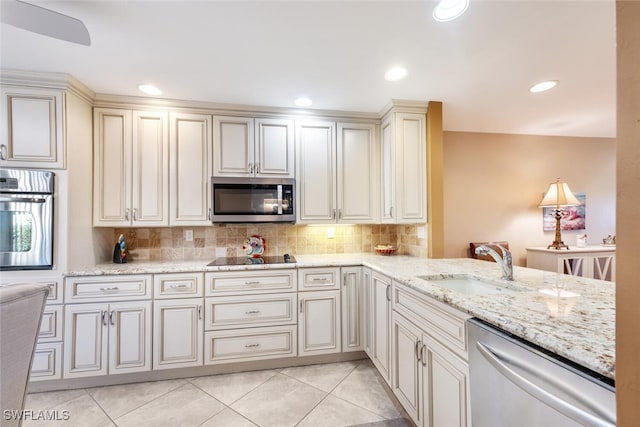 kitchen featuring sink, light tile patterned flooring, cream cabinets, and appliances with stainless steel finishes