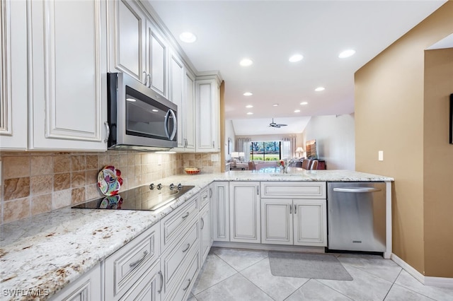 kitchen with light stone counters, light tile patterned floors, white cabinetry, appliances with stainless steel finishes, and ceiling fan