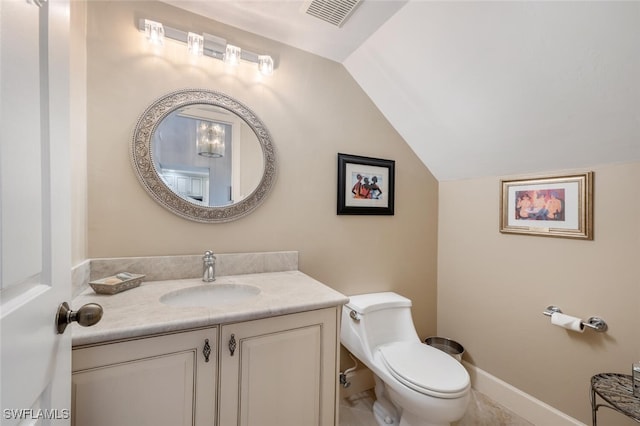 bathroom with lofted ceiling, toilet, and vanity