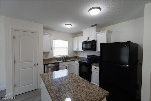 kitchen featuring a center island, black appliances, sink, light hardwood / wood-style floors, and white cabinetry