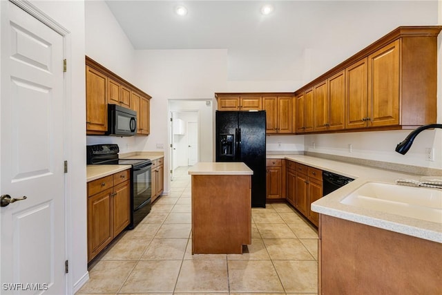 kitchen featuring sink, light tile patterned flooring, black appliances, and a center island