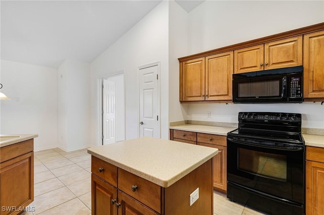 kitchen featuring black appliances, light tile patterned flooring, a center island, and lofted ceiling