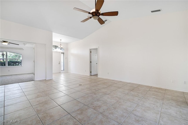 tiled spare room with ceiling fan with notable chandelier and high vaulted ceiling