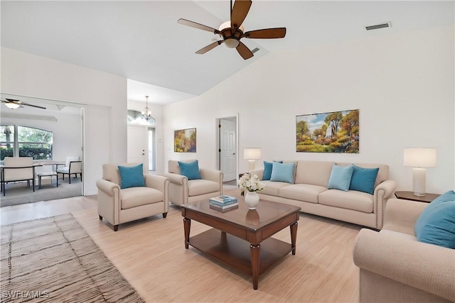 living room featuring ceiling fan with notable chandelier, high vaulted ceiling, and light hardwood / wood-style flooring