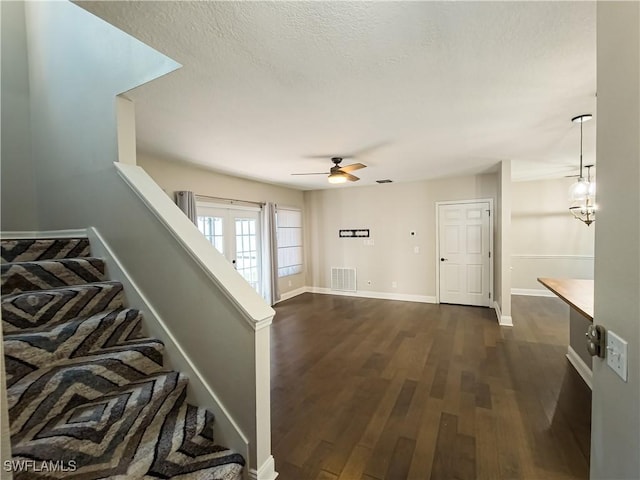 interior space featuring hardwood / wood-style floors and ceiling fan with notable chandelier