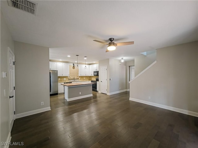 unfurnished living room with ceiling fan, sink, and dark wood-type flooring