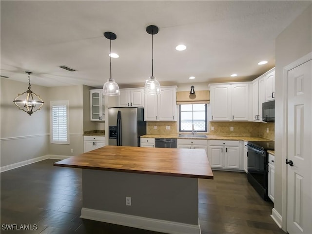 kitchen with wood counters, a center island, white cabinetry, and black appliances