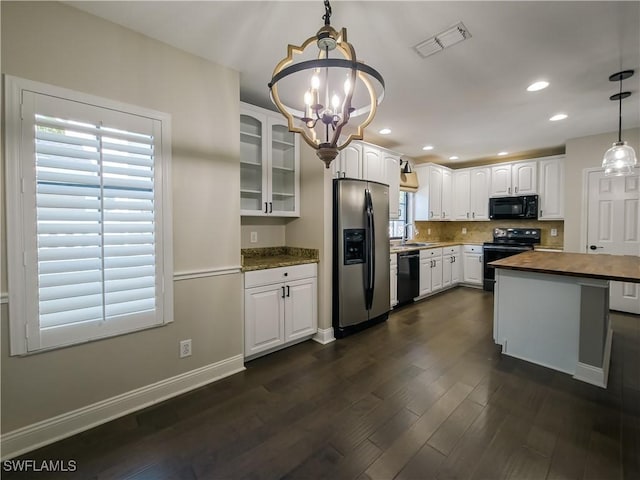 kitchen with an inviting chandelier, black appliances, white cabinets, decorative light fixtures, and butcher block counters