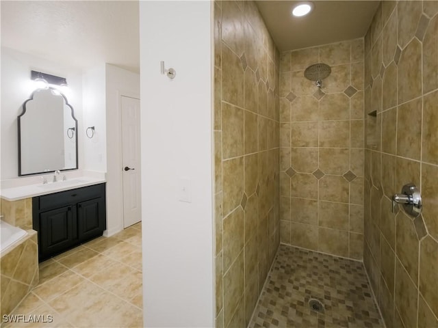 bathroom with a tile shower and vanity