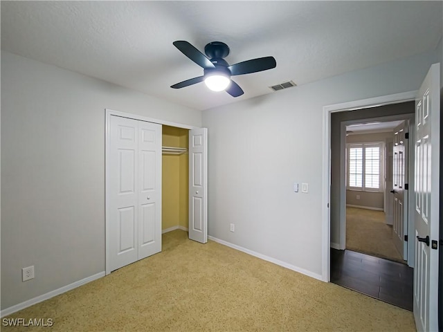 unfurnished bedroom featuring a closet, ceiling fan, and light colored carpet