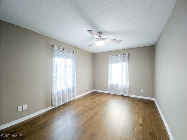 empty room with hardwood / wood-style flooring, plenty of natural light, ceiling fan, and a textured ceiling