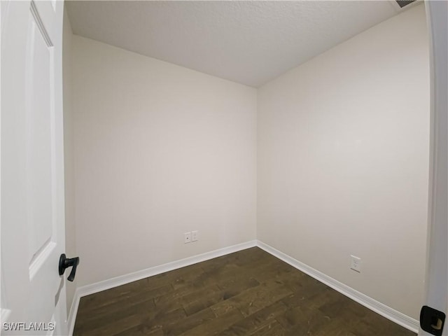 unfurnished room with dark hardwood / wood-style flooring