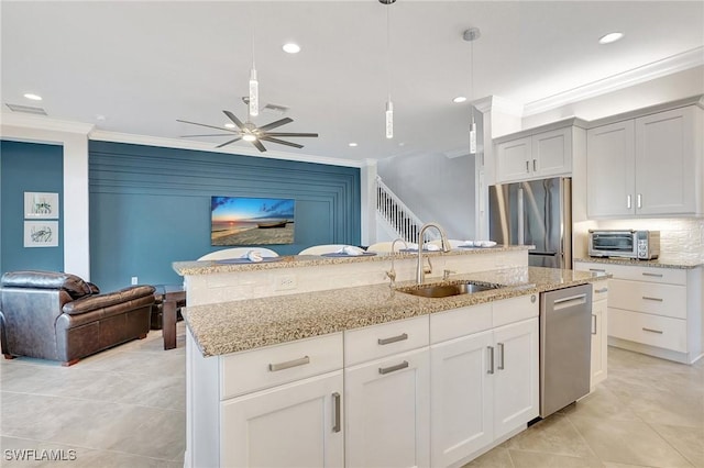 10064 Chesapeake Bay Dr, Fort Myers, FL 33913 - kitchen featuring appliances with stainless steel finishes, a sink, crown molding, open floor plan, and light stone countertops
