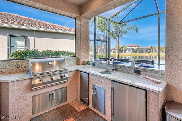 view of patio with area for grilling, sink, grilling area, and a water view