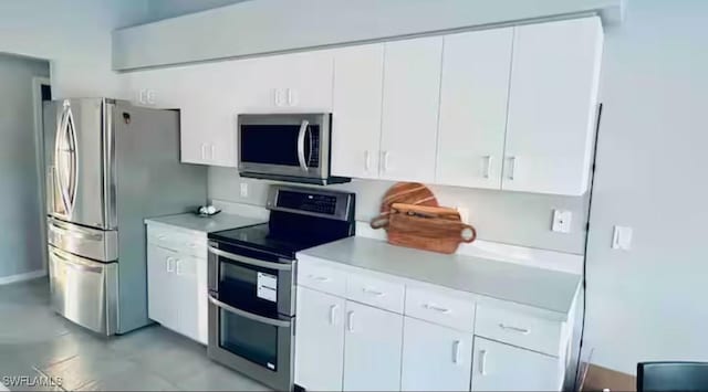 kitchen with white cabinets, stainless steel appliances, and light tile patterned flooring