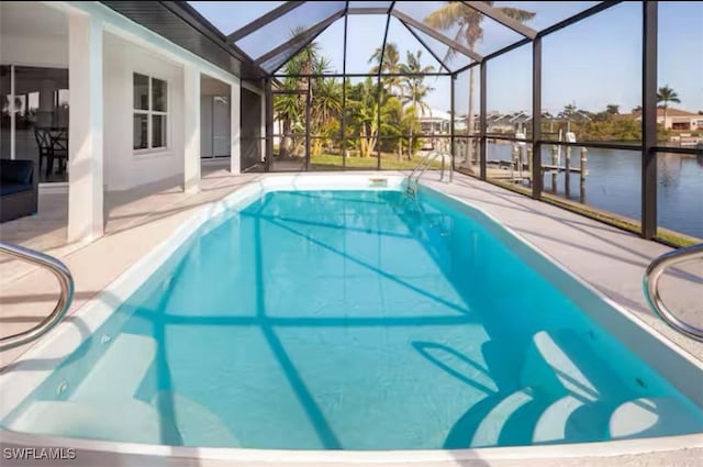 view of pool with a patio, a water view, and a lanai