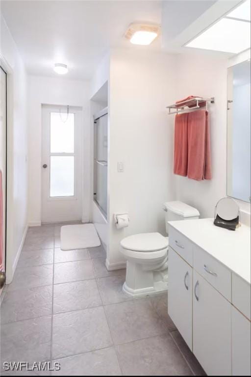 bathroom with vanity, toilet, and a shower with door