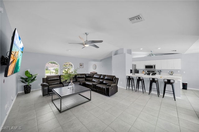 living area with baseboards, visible vents, a ceiling fan, and lofted ceiling