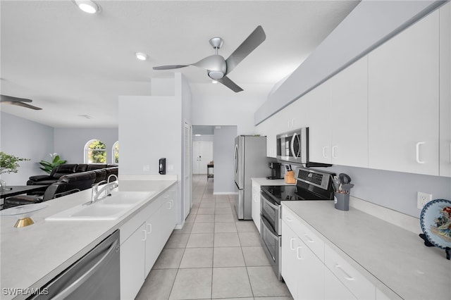 kitchen with a ceiling fan, a sink, stainless steel appliances, and light countertops