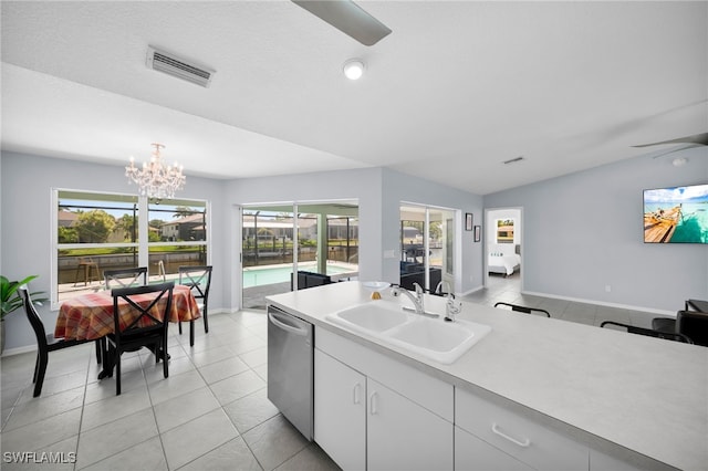 kitchen with light countertops, ceiling fan with notable chandelier, dishwasher, a sink, and visible vents