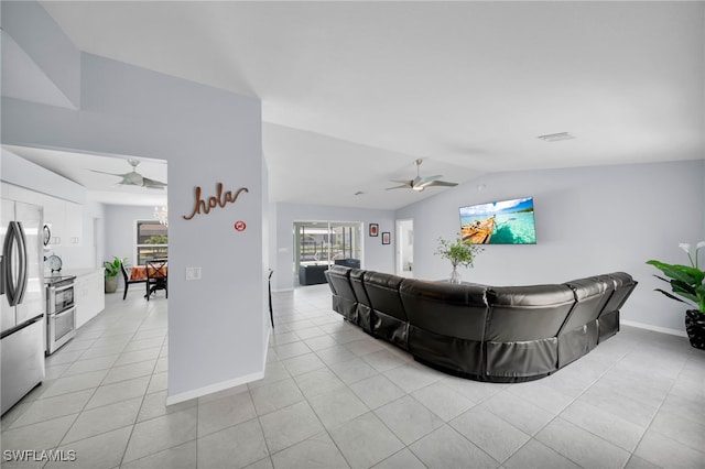 living room featuring light tile patterned floors, a ceiling fan, and vaulted ceiling