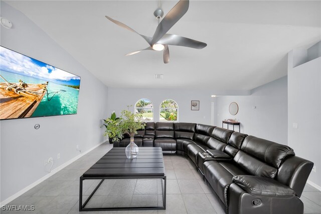 living room featuring baseboards, light tile patterned floors, and ceiling fan