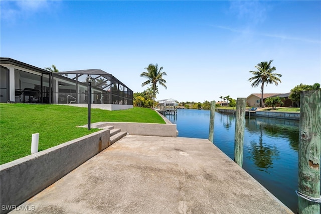 view of dock with a yard and a water view