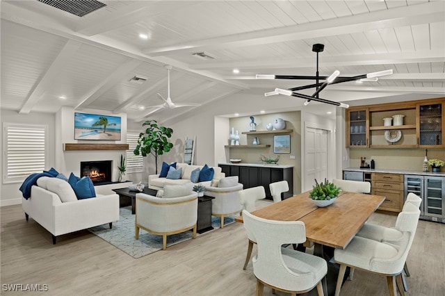 dining room featuring lofted ceiling with beams, light hardwood / wood-style floors, an inviting chandelier, and beverage cooler