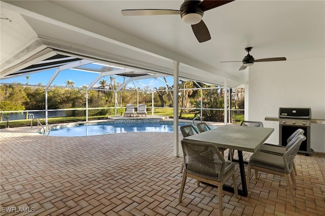 view of pool featuring glass enclosure, a patio area, and grilling area