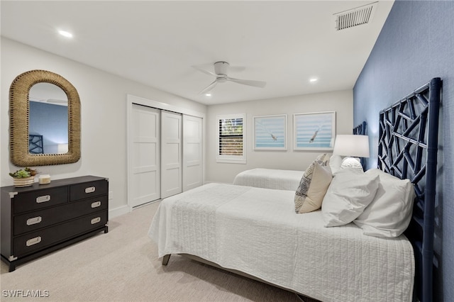 carpeted bedroom with ceiling fan and a closet