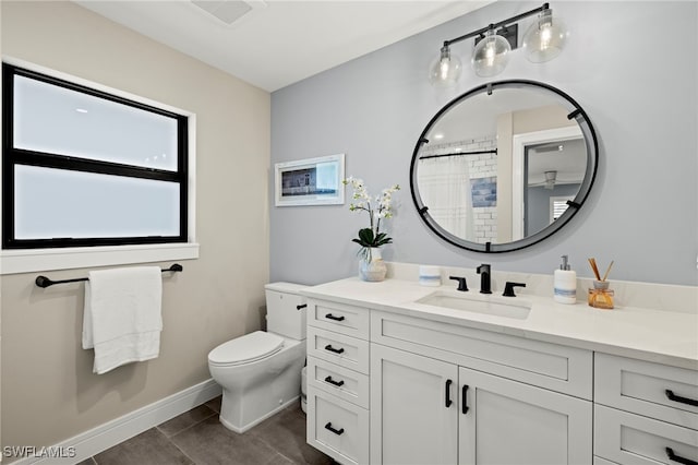 bathroom featuring tile patterned flooring, vanity, curtained shower, and toilet