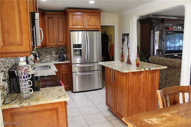 kitchen with backsplash, light stone counters, ornamental molding, stainless steel fridge with ice dispenser, and a center island