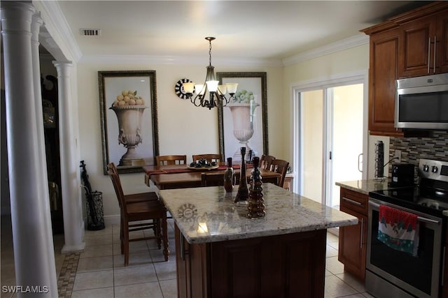 kitchen featuring a chandelier, appliances with stainless steel finishes, a center island, and light tile patterned floors