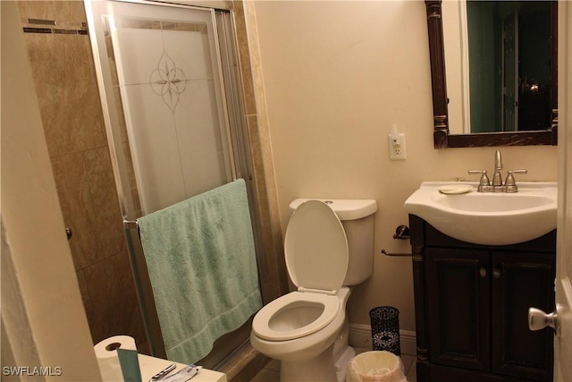 bathroom with vanity, a shower with shower door, and toilet