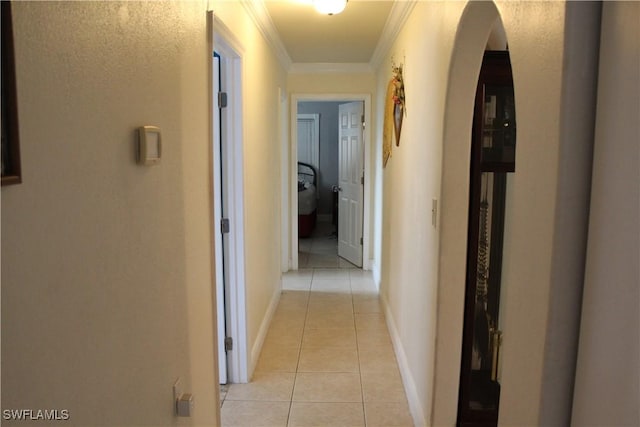 hallway with light tile patterned flooring and crown molding