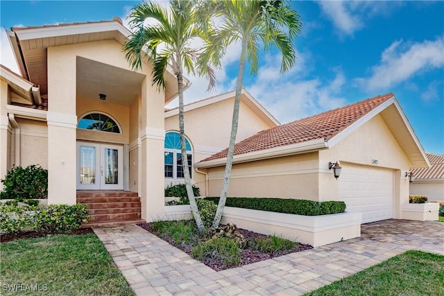 5471 Harborage Dr, Fort Myers, FL 33908 - exterior space featuring a tile roof, french doors, a garage, and stucco siding