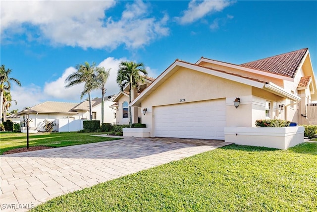 5471 Harborage Dr, Fort Myers, FL 33908 - view of front of property featuring a front yard, a garage, driveway, and stucco siding