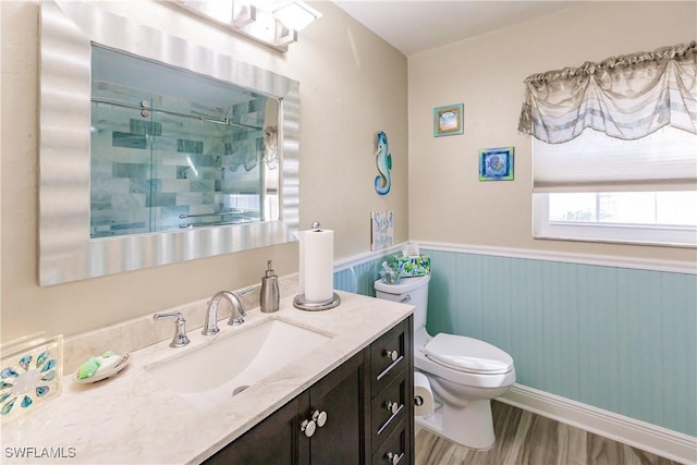 5471 Harborage Dr, Fort Myers, FL 33908 - bathroom with vanity, wood finished floors, a shower stall, wainscoting, and toilet