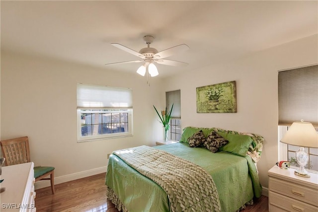 bedroom with ceiling fan, baseboards, and wood finished floors