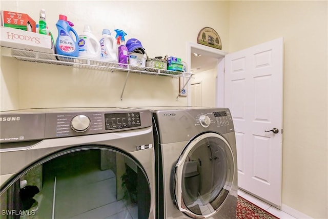 laundry area featuring washing machine and clothes dryer and tile patterned floors