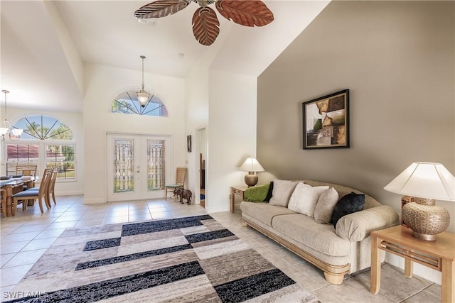 5471 Harborage Dr, Fort Myers, FL 33908 - living room with visible vents, baseboards, light tile patterned floors, ceiling fan with notable chandelier, and high vaulted ceiling